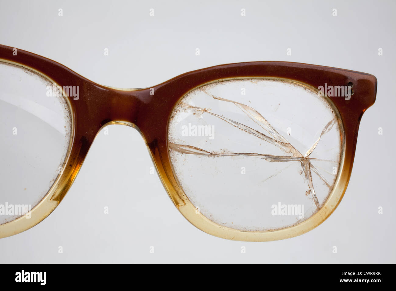 Una vieja bocina-enculado gafas con una lente agrietado Fotografía de stock  - Alamy