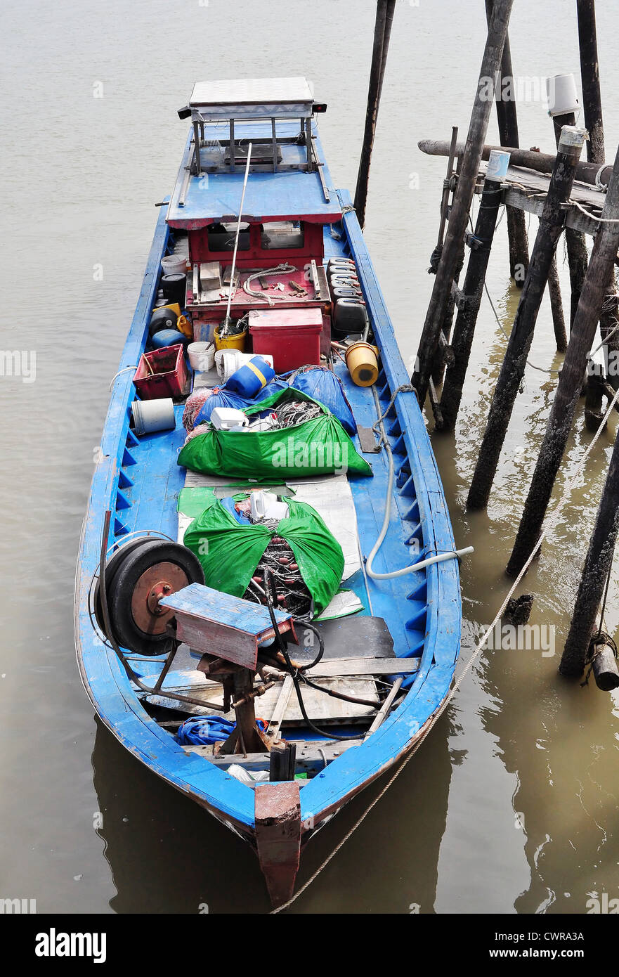 Un barco azul que está estacionado en una aldea de pescadores Foto de stock