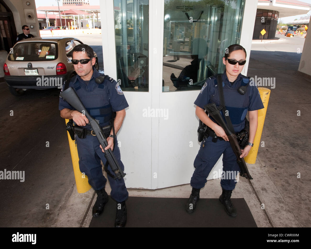 Los funcionarios y funcionarias, guardia con pistolas en el puente internacional de Laredo, Texas. Foto de stock