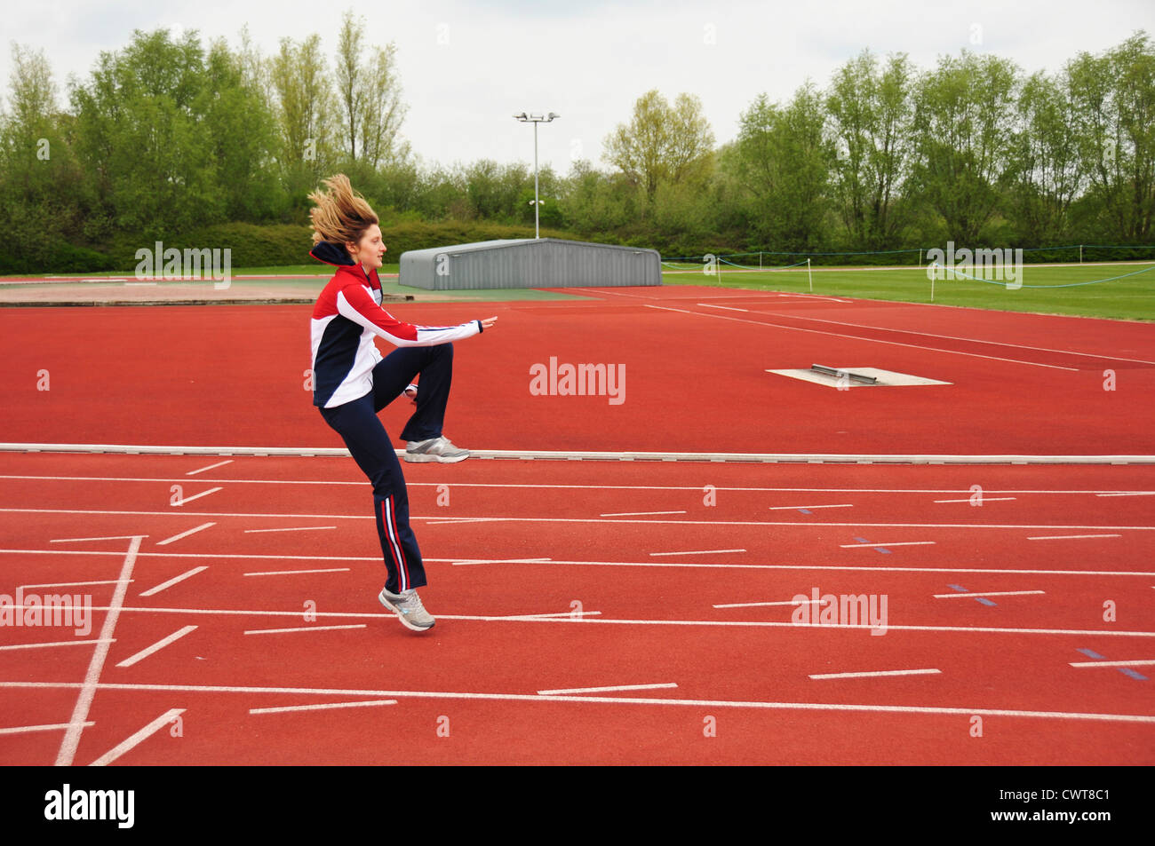 Atleta Femenina haciendo ejercicio, ejercicios, entrenamiento en la pista de atletismo Foto de stock