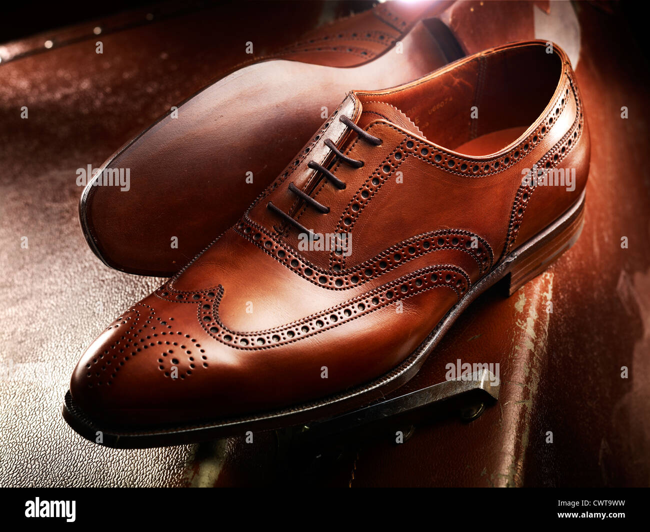 Caro de lujo de cuero marrón zapatos brogue en una maleta de cuero vintage Foto de stock