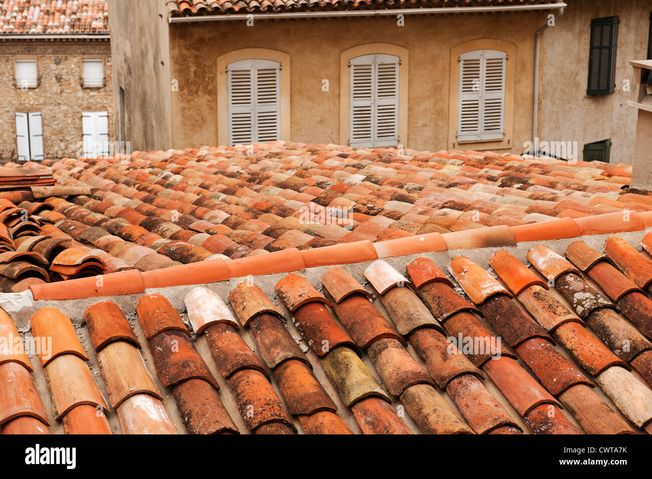 Una vista sobre un techo de tejas terracota hacia las ventanas con persianas en Callas, Provenza, Francia, Europa Foto de stock