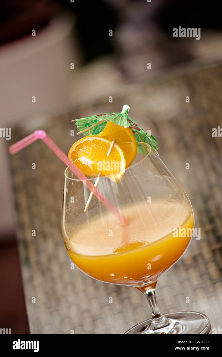 Un vaso con un cóctel de naranja Foto de stock