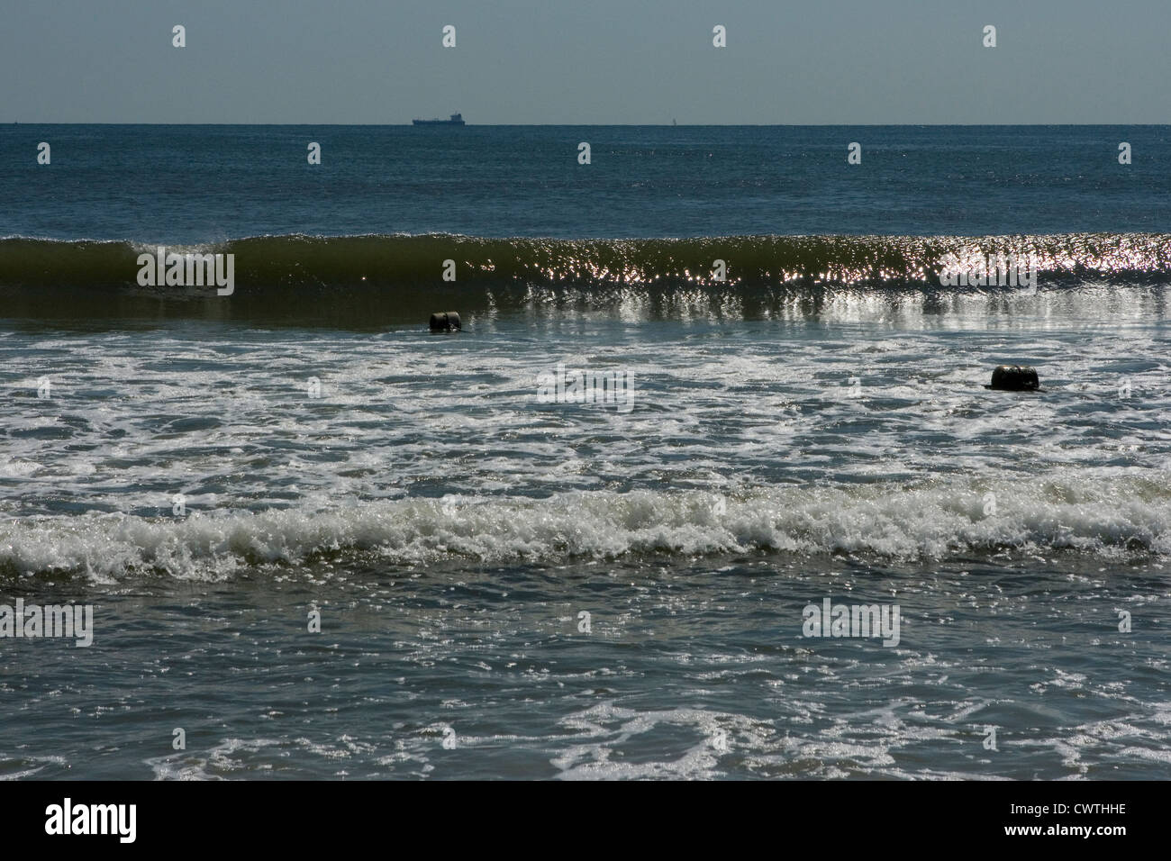 Ola rompiendo con barco en el horizonte. Atlantic Beach, NY Foto de stock