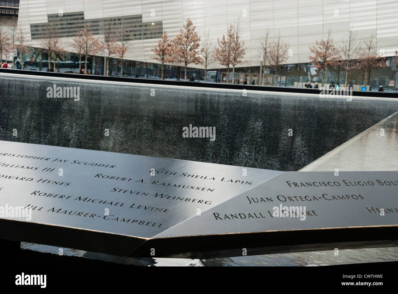 National Memorial del 11 de septiembre muestra nombres en el parapeto que rodea la piscina y el museo en el fondo. Foto de stock