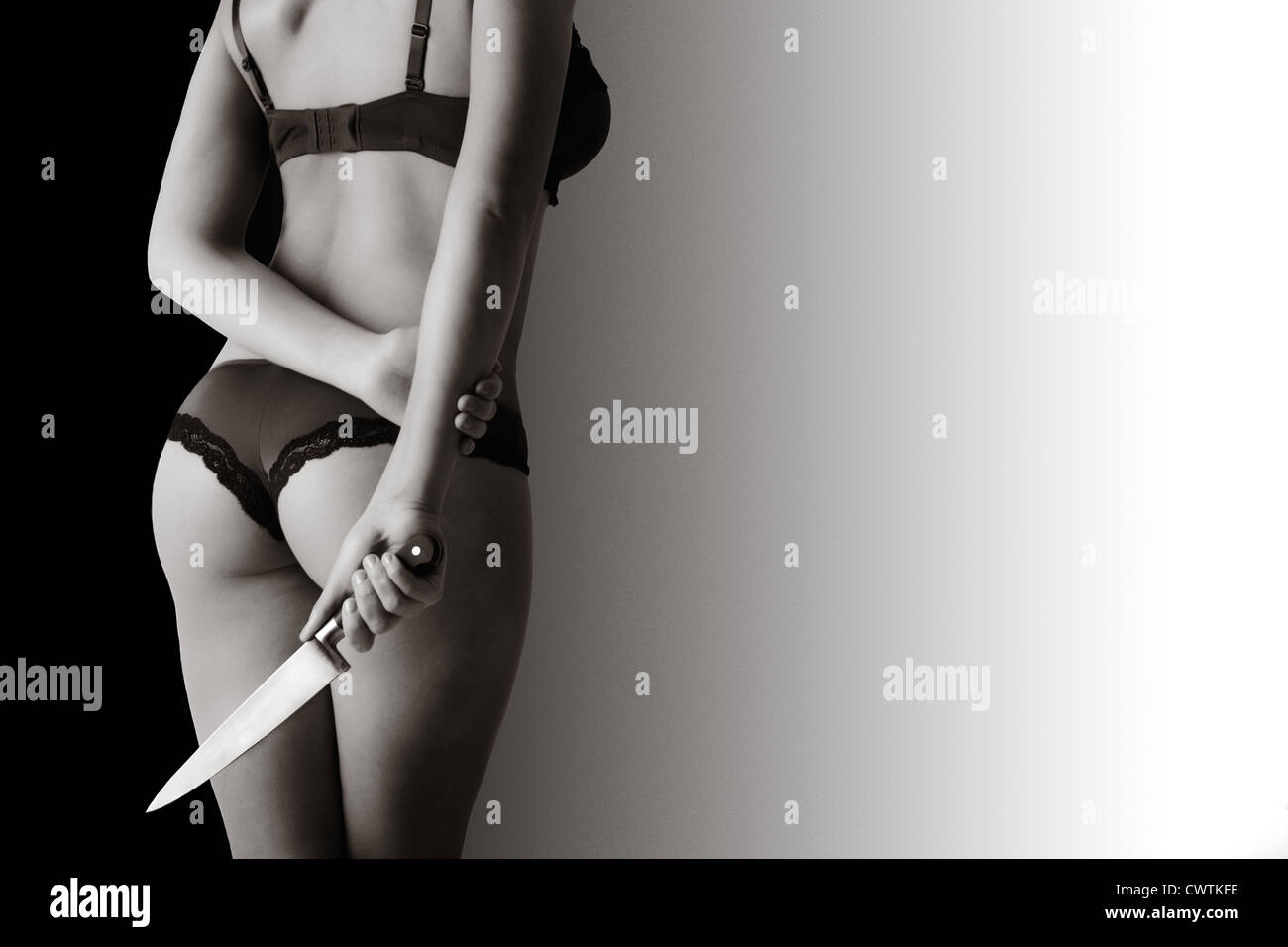Mujer sexy con su espalda a la cámara en ropa interior las manos hacia abajo por lado en una mano que sostiene un cuchillo Fotografía de stock - Alamy