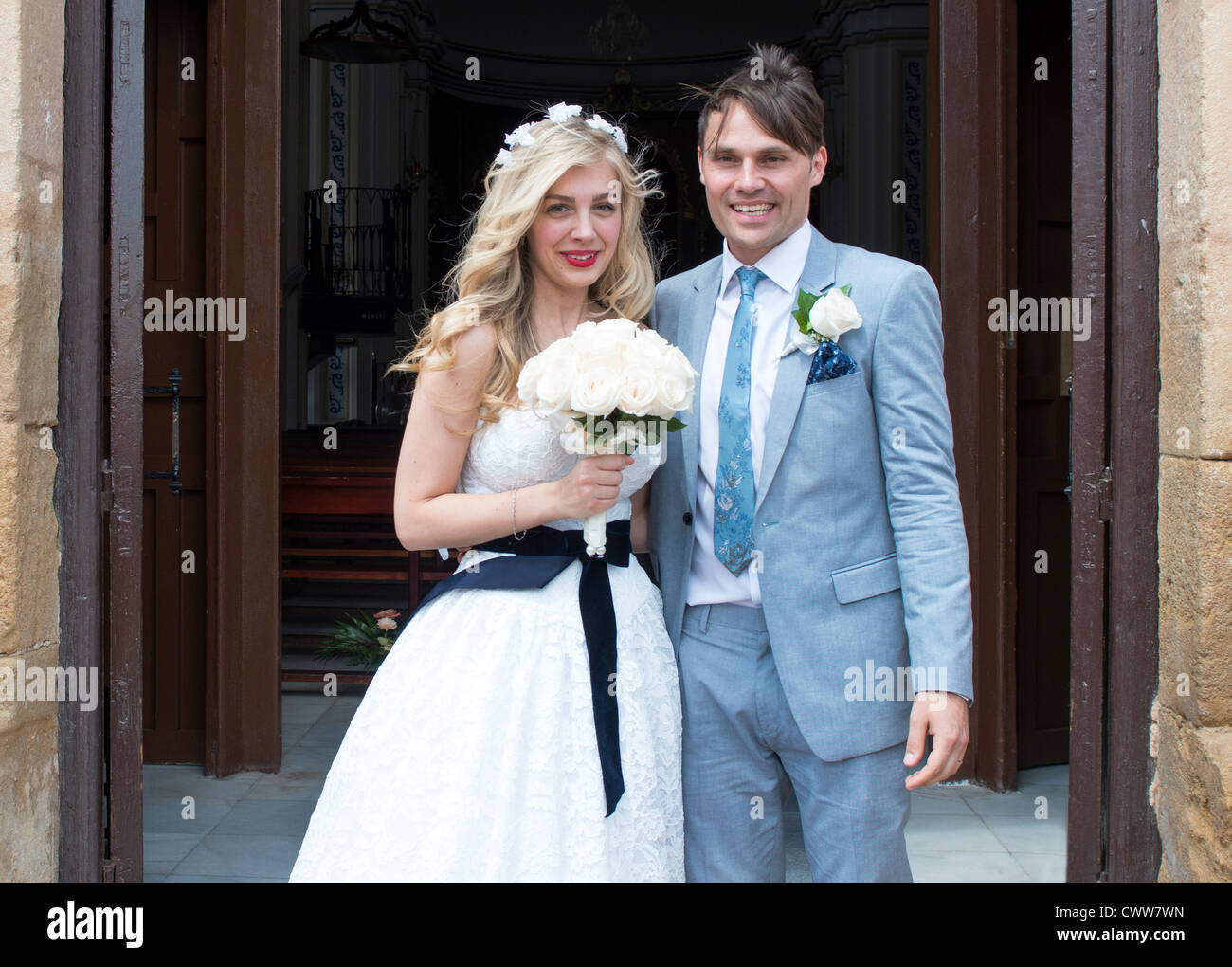 La novia y el novio de pie fuera de la iglesia en España justo después de la ceremonia de la boda Foto de stock