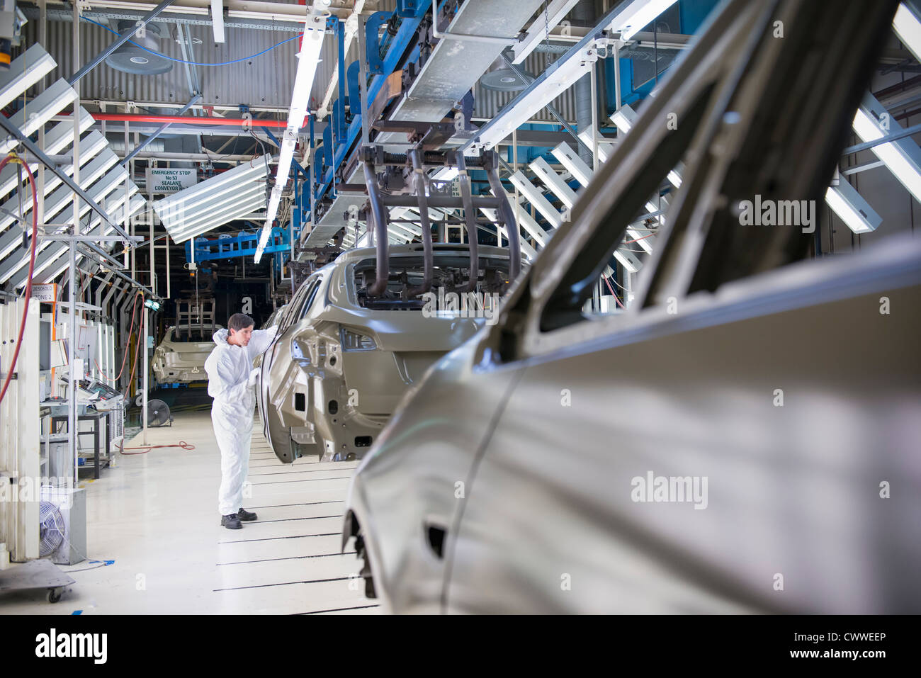 Inspección del trabajador en la carrocería del coche en la fábrica de coches Foto de stock