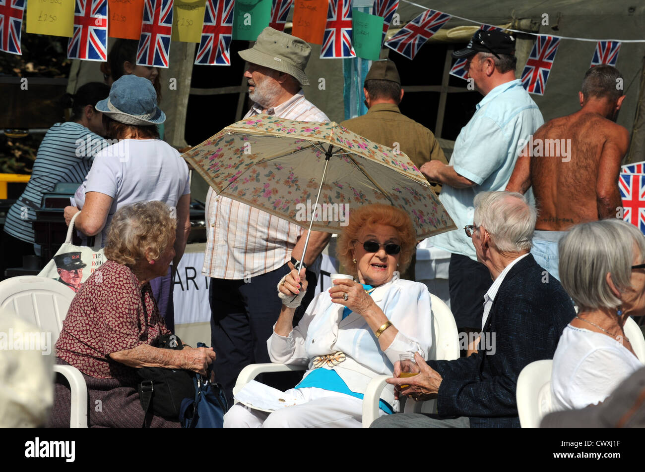 Esta señora proteger del sol con un paraguas a los veteranos ciegos UK Vintage Feria anual en Ovingdean hoy Foto de stock