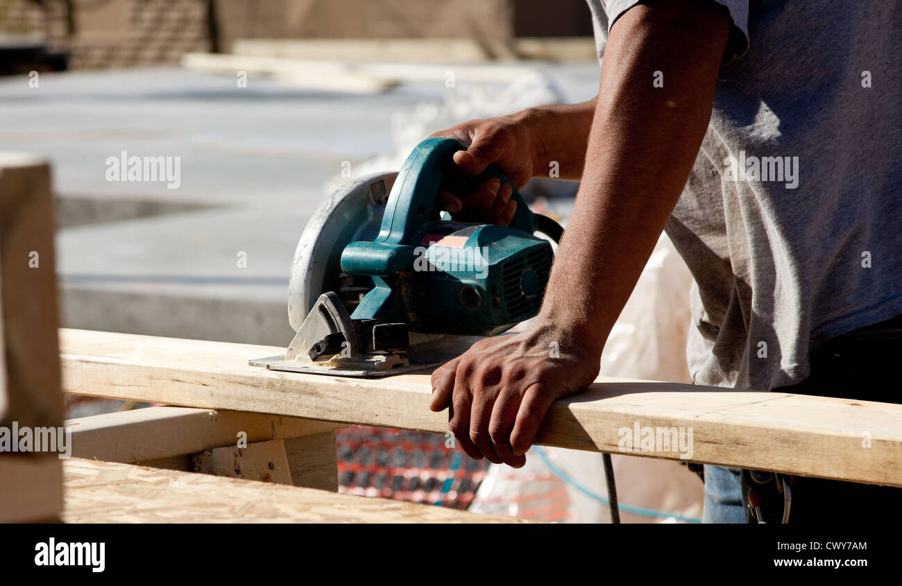 Un trabajador de la construcción utilizando una sierra circular Foto de stock