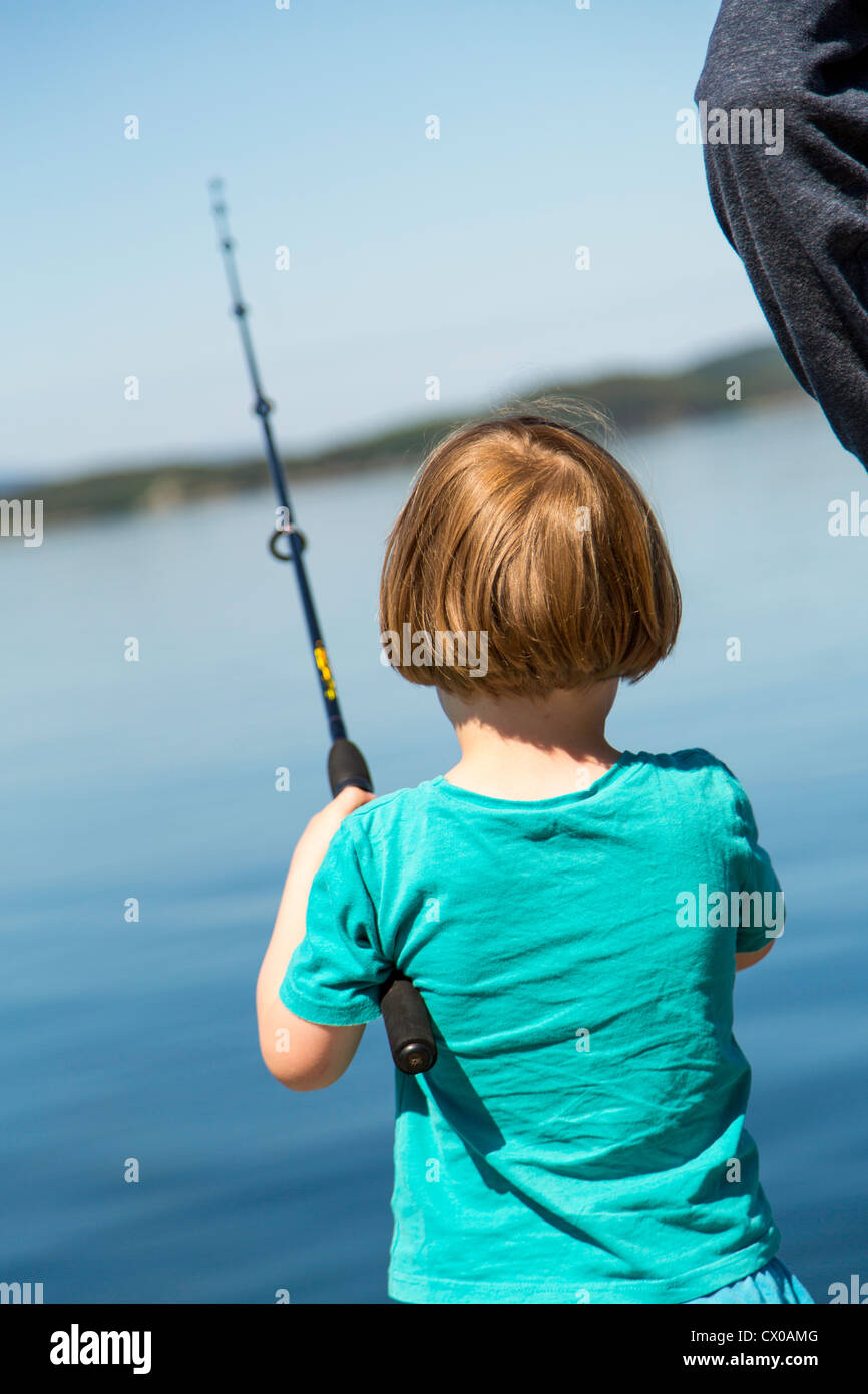 Vista trasera de un chico de pesca con su padre Foto de stock