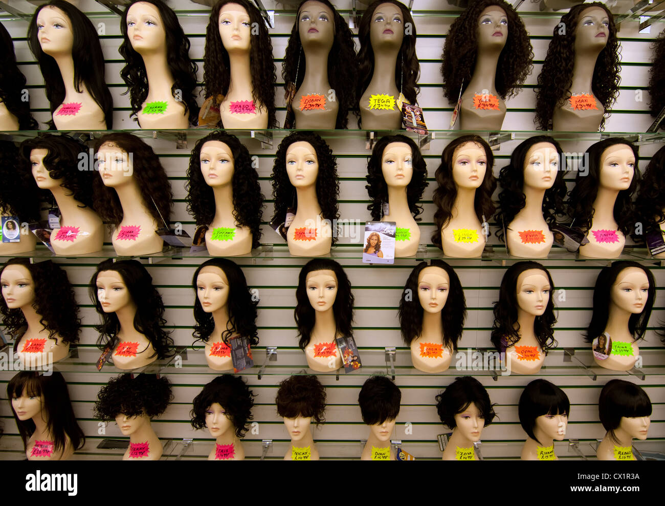 Una pantalla de pelucas desde una tienda en Queens mercado upton park London E13 Foto de stock