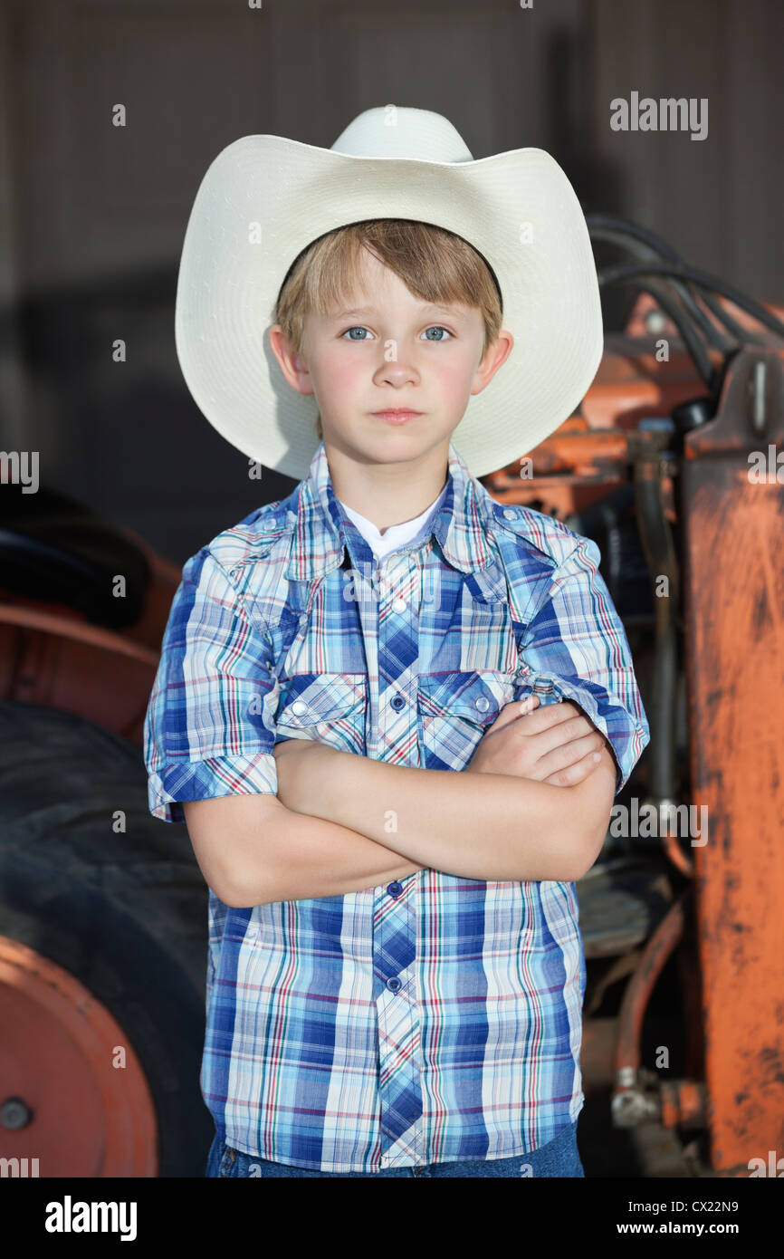 Retrato de un niño llevar sombrero de cowboy mientras está de pie con los  brazos cruzados contra la máquina Fotografía de stock - Alamy
