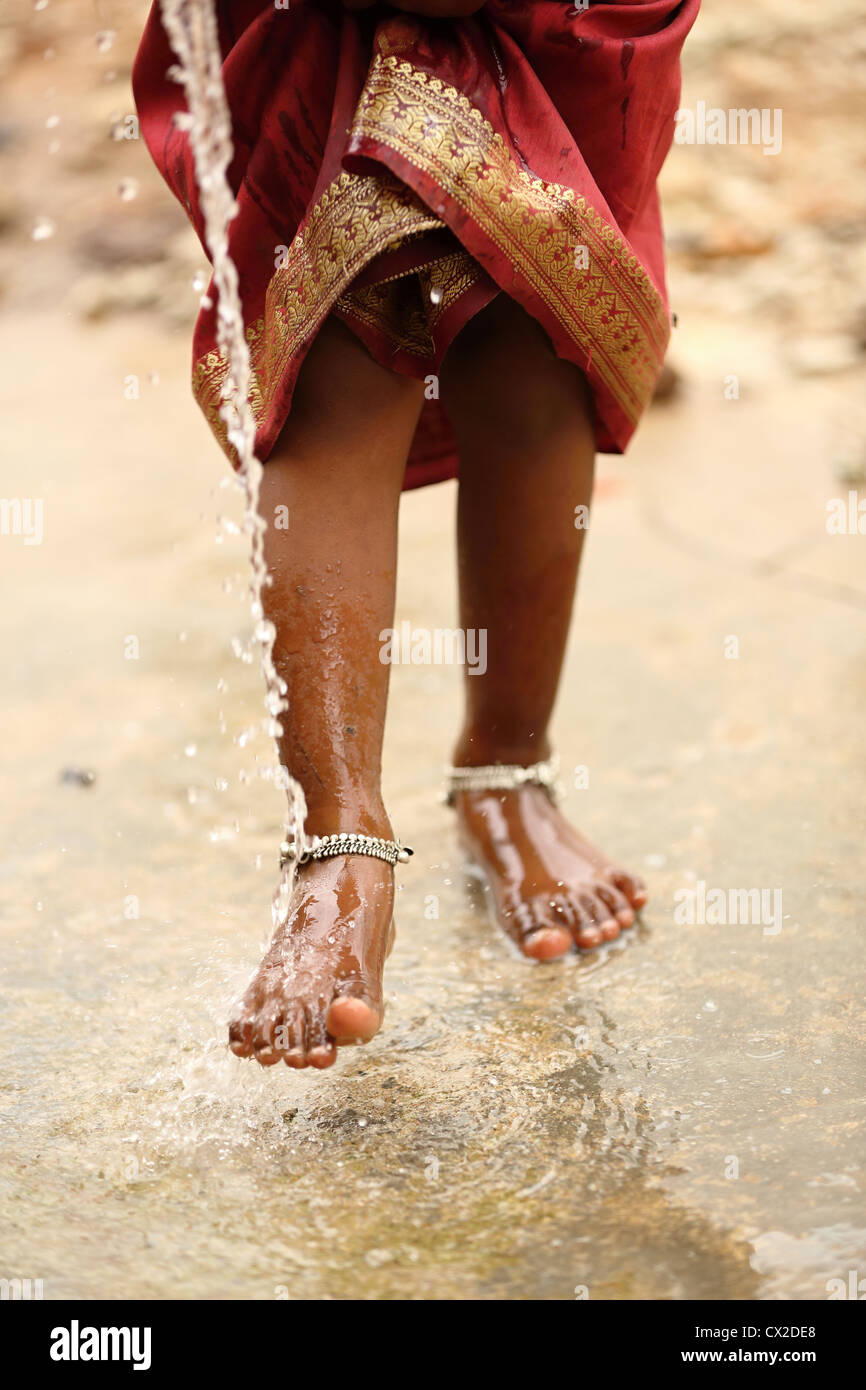 Joven indígena Karuna lavando sus pies en Andhra Pradesh en el sur de la India Foto de stock