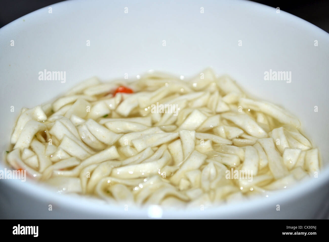 Una taza de sopa de pollo con fideos en sopa de sabor taza Foto de stock