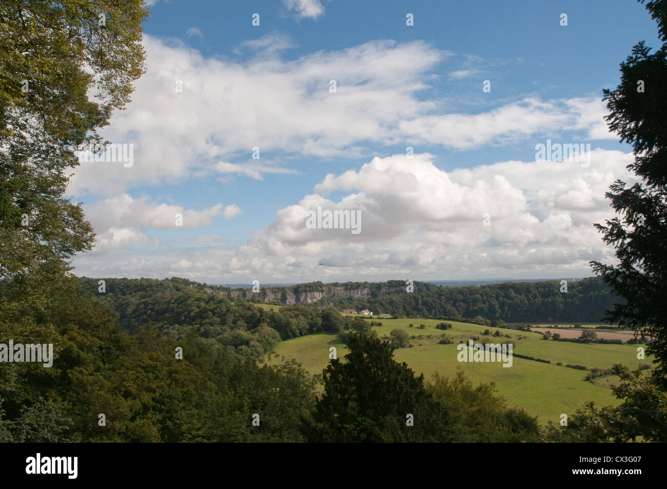 Los paisajes rurales, campos, bosques, distante cantera, cielo azul, nubes blancas, enmarcadas con árboles cercanos Foto de stock