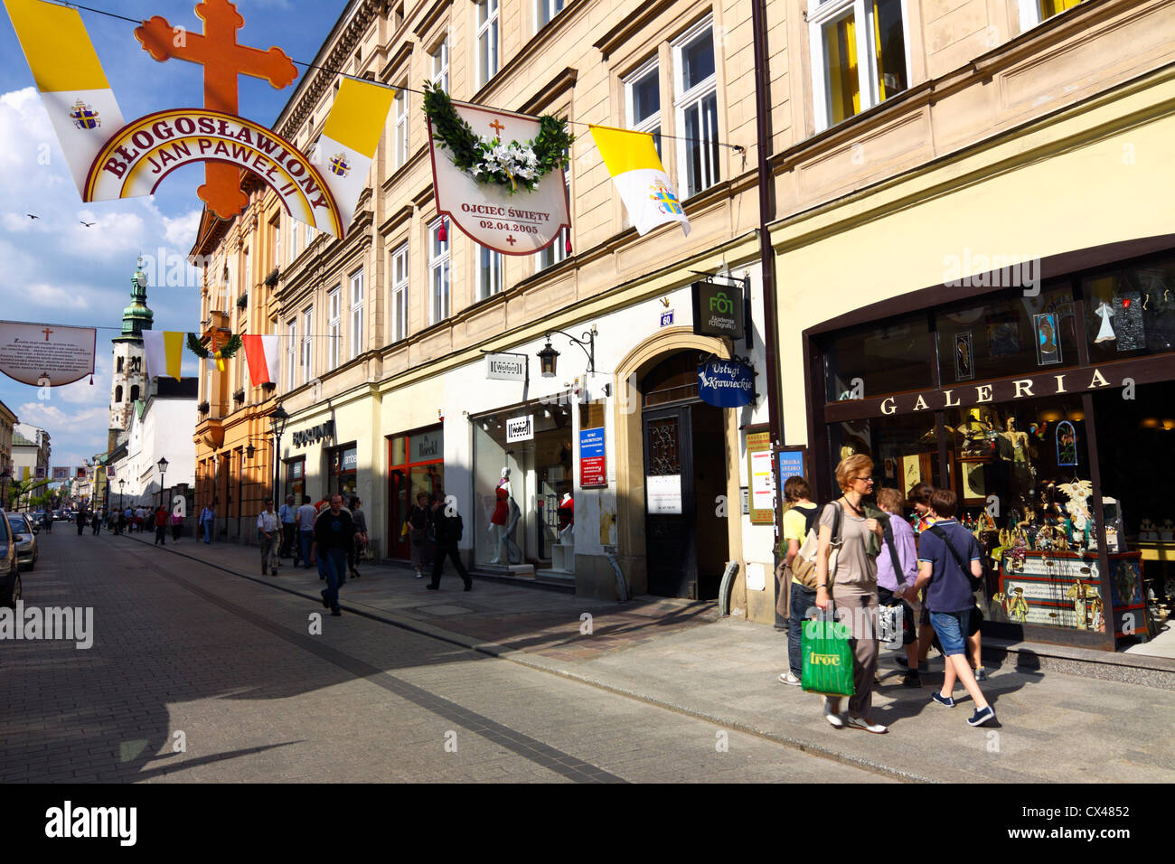 La calle Grodzka Krakows con decoración conmemorativa de la beatificación de Juan Pablo II y la gente caminando y compras. Polonia Foto de stock