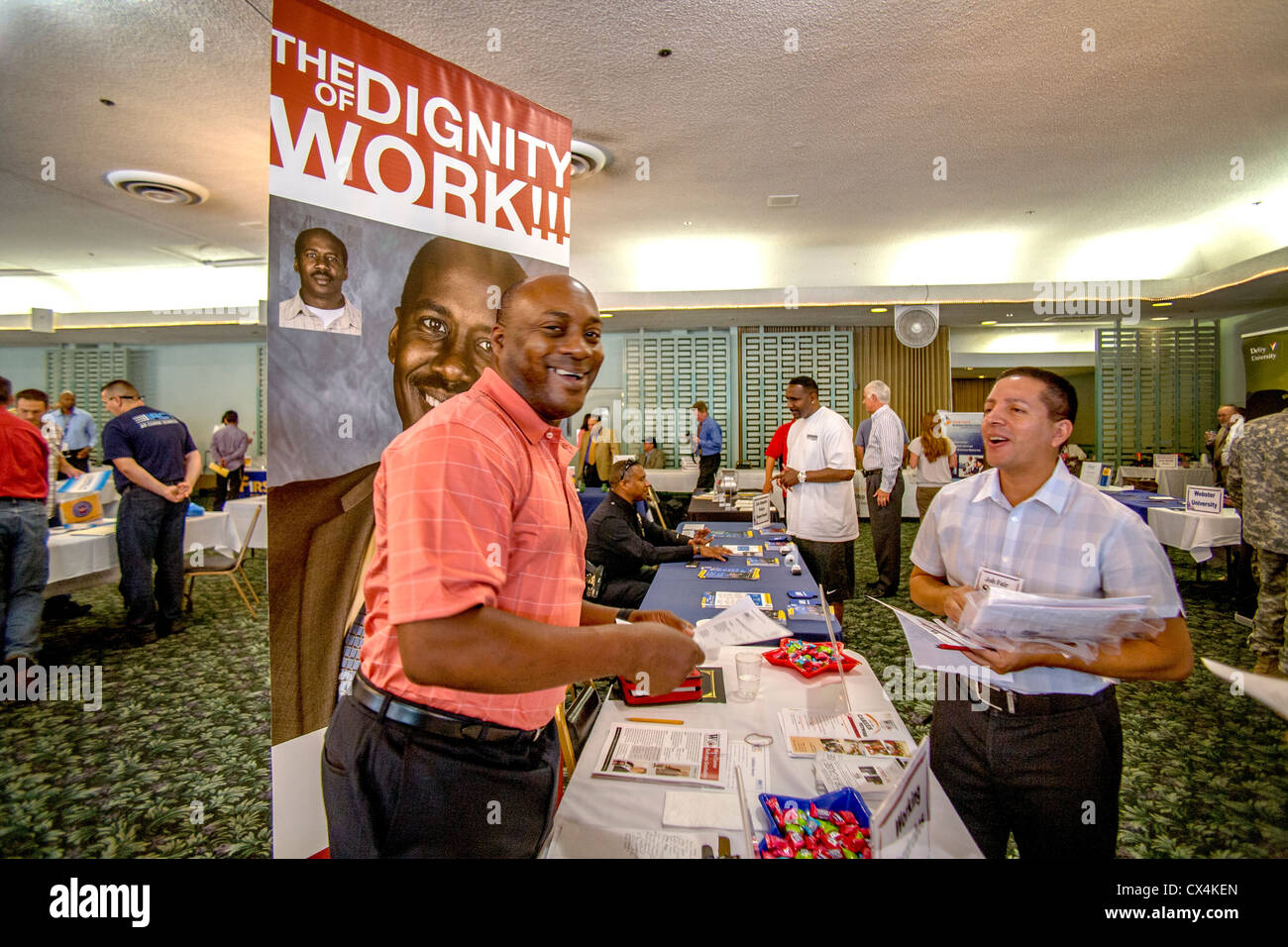 Un Afroamericano jolly recuerda a los solicitantes de empleo de la dignidad del trabajo en una feria de empleo para veteranos militares en Santa Ana, CA. Foto de stock