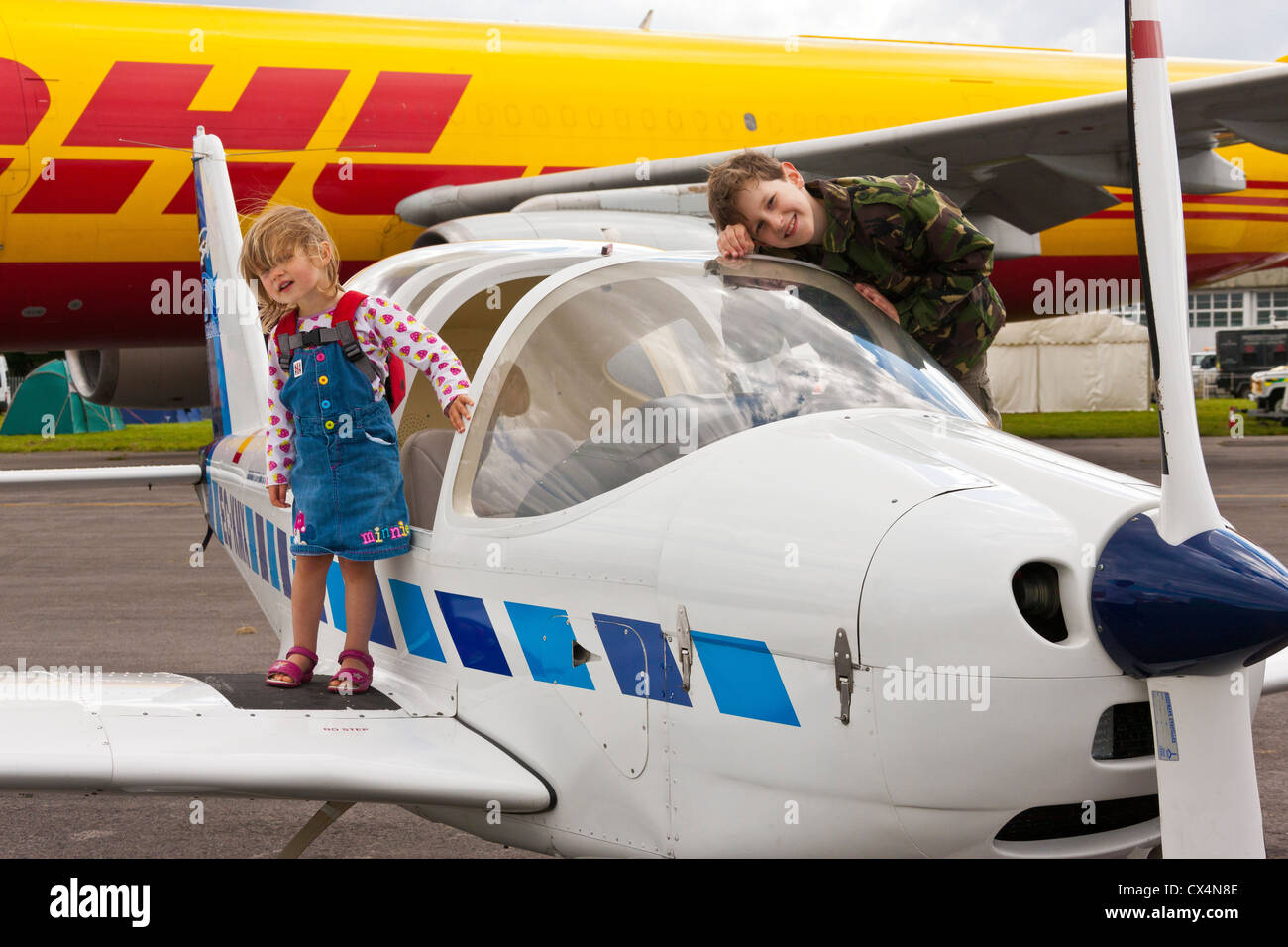 Los niños explorando un avión ligero a lo mejor del espectáculo británico, Cotswold (Kemble EGBP) del aeropuerto. JMH6074 Foto de stock