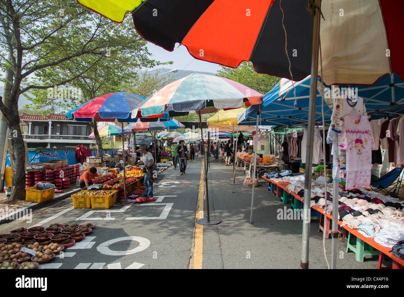 Coloridas sombrillas y los vendedores ambulantes en el mercado al aire libre en Jinhae, Corea del Sur Foto de stock