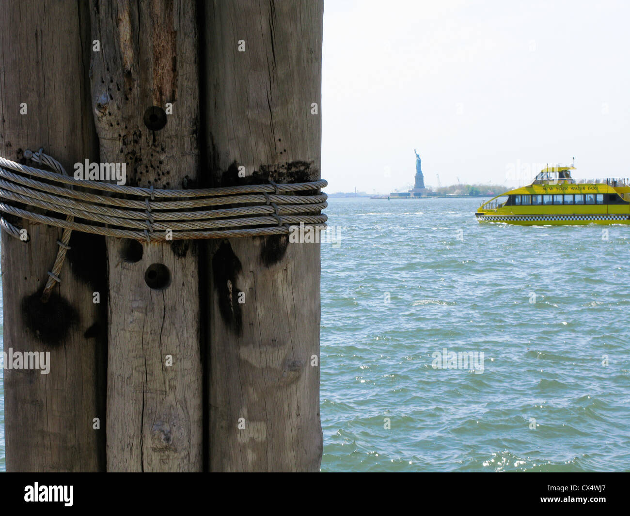 La estatua de la Libertad, en la distancia, el ferry, muelle de madera
