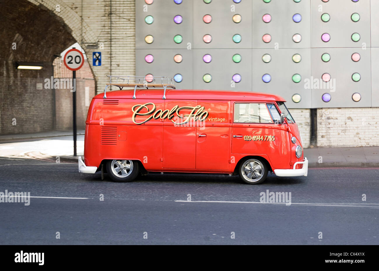 Rojo brillante vintage VW camper van cool flo en carretera en entorno  urbano Fotografía de stock - Alamy