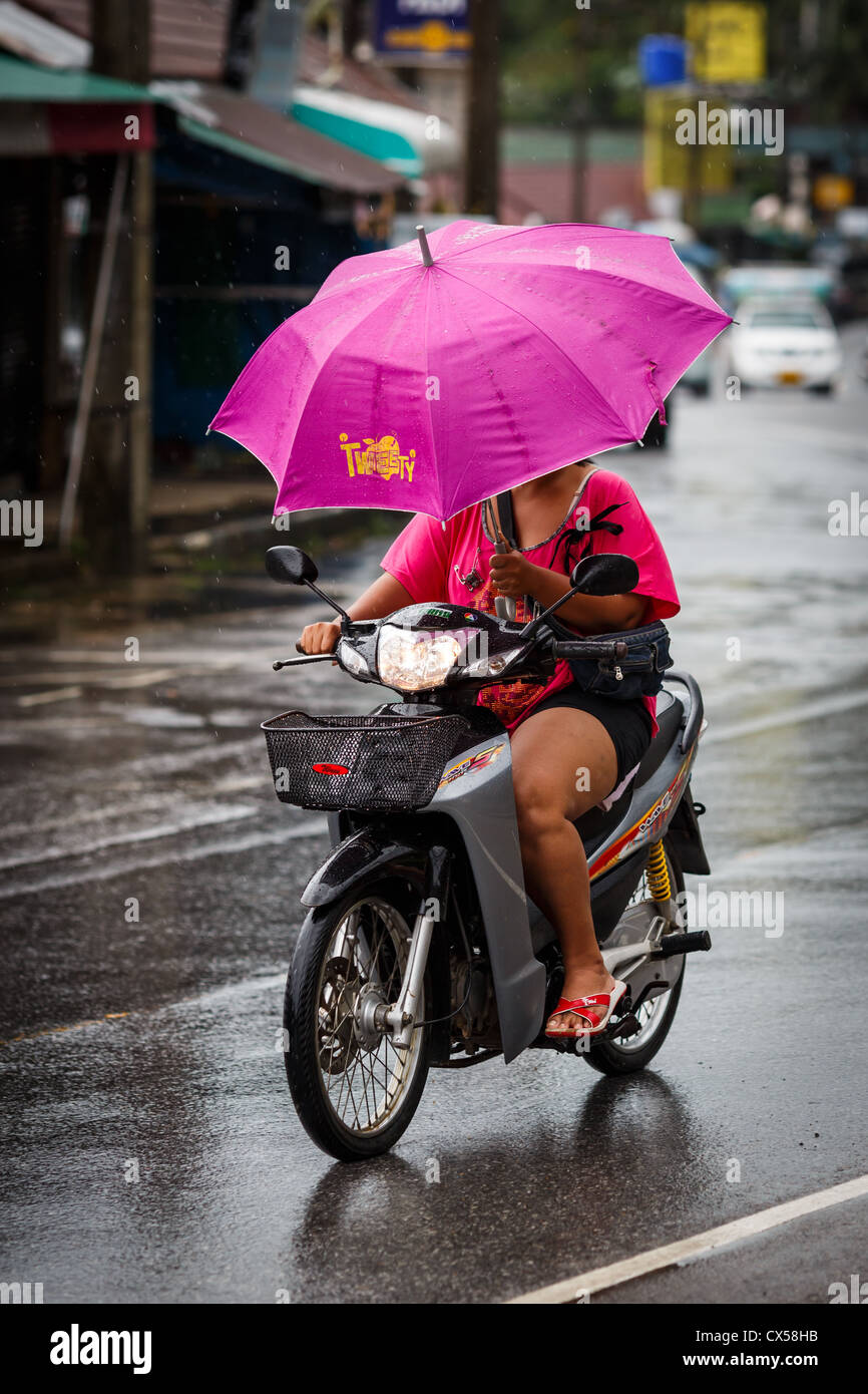 La moto hembra con un paraguas en una mano, Koh Chang, Tailandia Fotografía  de stock - Alamy