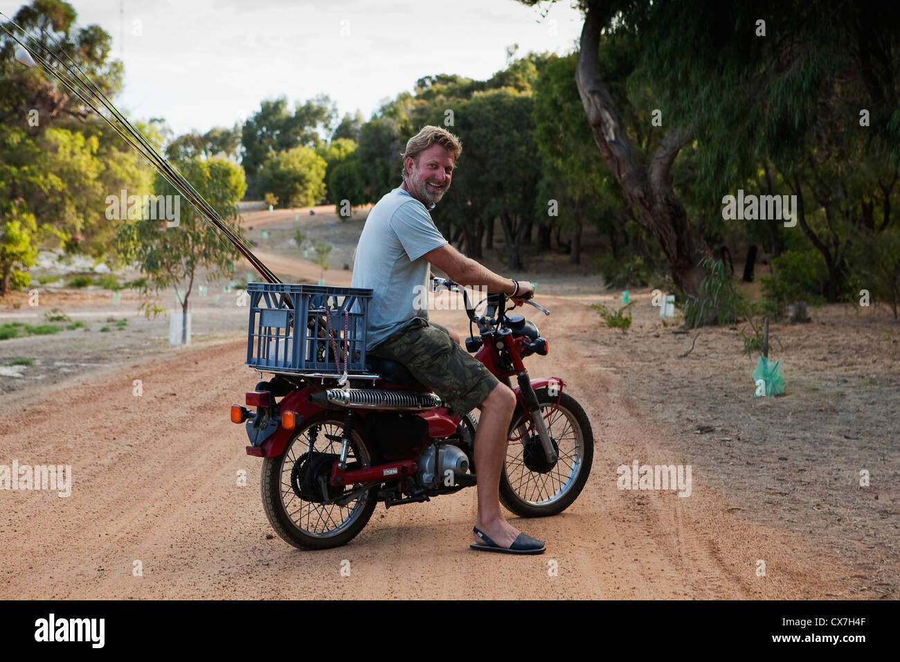 Un hombre montado en una moto con una cesta en la espalda; Dunsborough,  Australia Occidental, Australia Fotografía de stock - Alamy