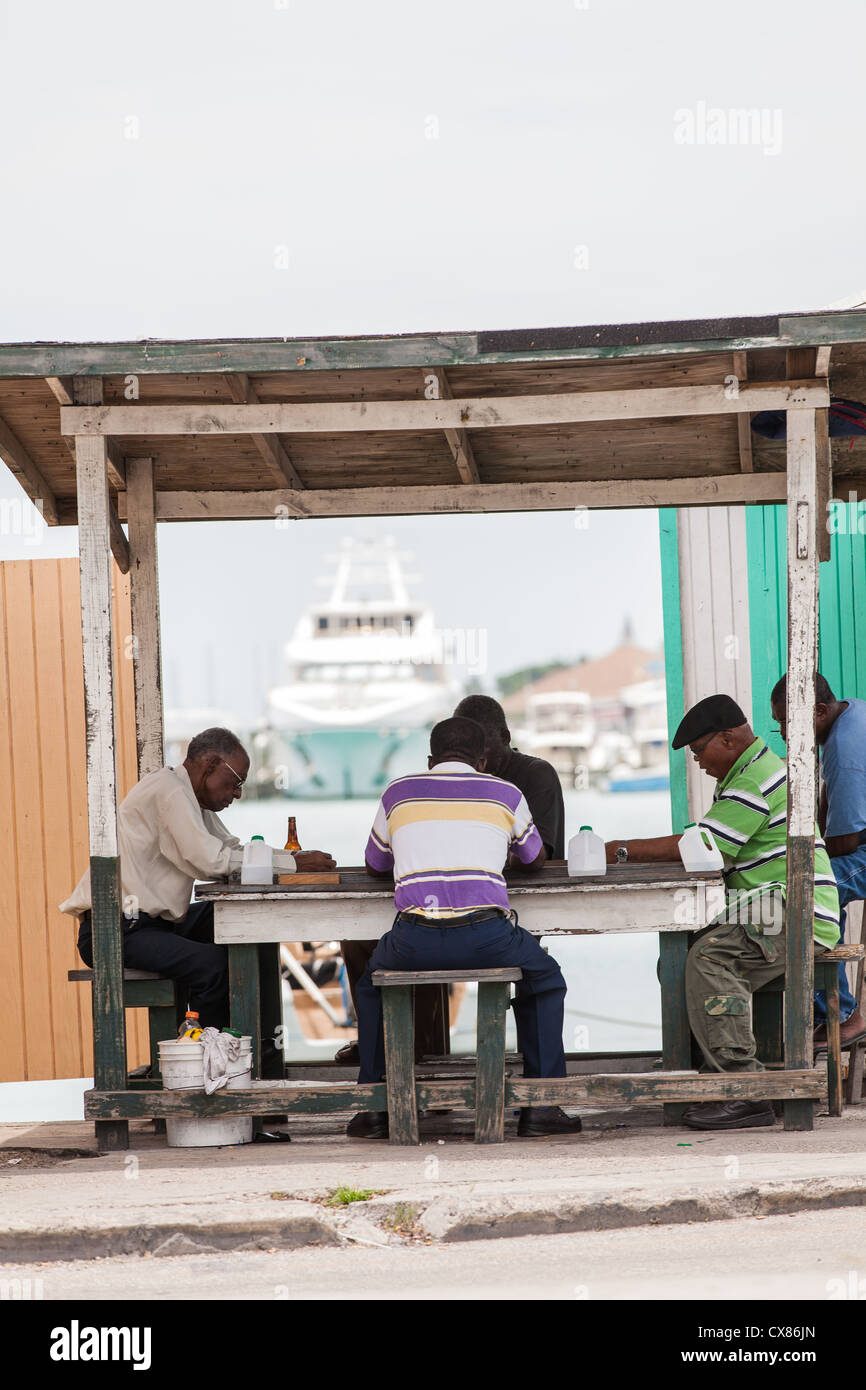 Los hombres de jugar a las cartas en un puesto de comida en la carretera a Potter's Cay en Nassau, Bahamas. Foto de stock