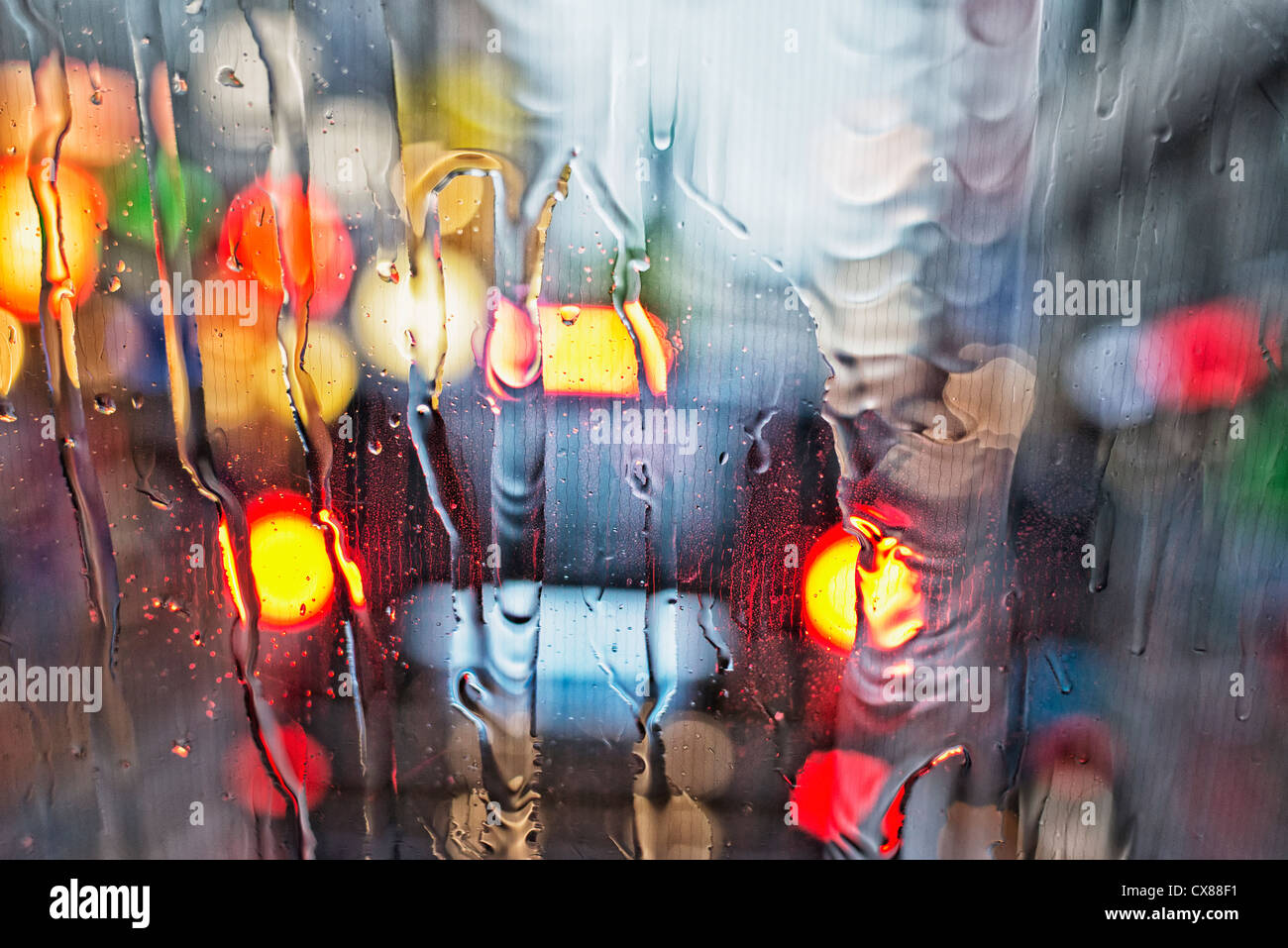 Vista de una de las luces traseras del coche a través de un parabrisas mojado; Ámsterdam, Holanda Foto de stock