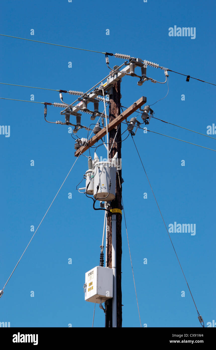 Poste de la línea de alimentación transformadores eléctricos montados sobre un poste de la línea de alimentación. También se ven aislantes cerámicos. California, EE.UU. Foto de stock
