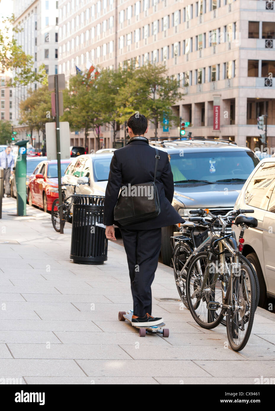 Un joven profesional montando un monopatín en la ciudad - Washington DC, EE.UU. Foto de stock