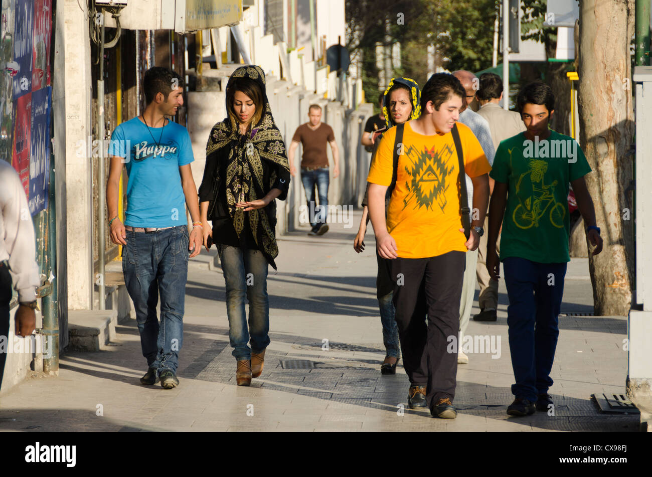 Hombre y mujer adolescente vestida con ropa occidental, caminar juntos en la Tajrish, en el norte de Teherán Foto de stock