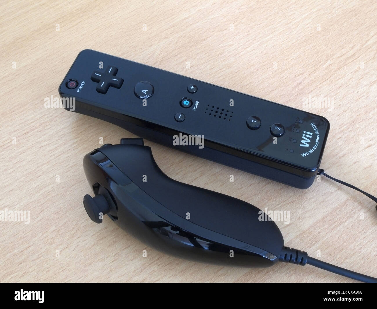 Nintendo Wii Remote y Nunchuck controlador negro sobre un fondo de madera Foto de stock