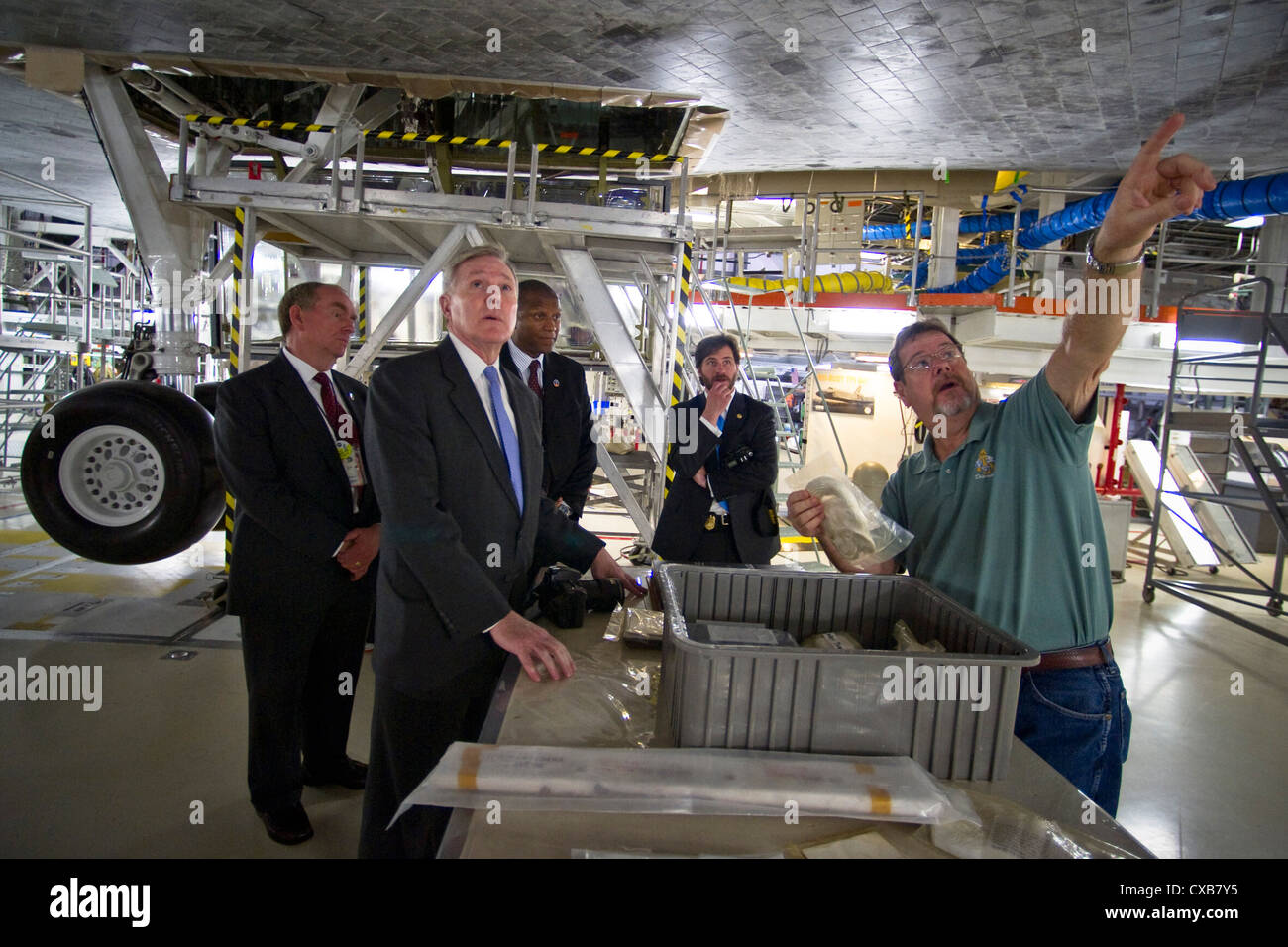 El secretario de la marina, el honorable ray mabus, está debajo del transbordador espacial Atlantis durante una visita a las instalaciones de procesamiento del Orbitador de la NASA en el Centro Espacial Kennedy. Foto de stock