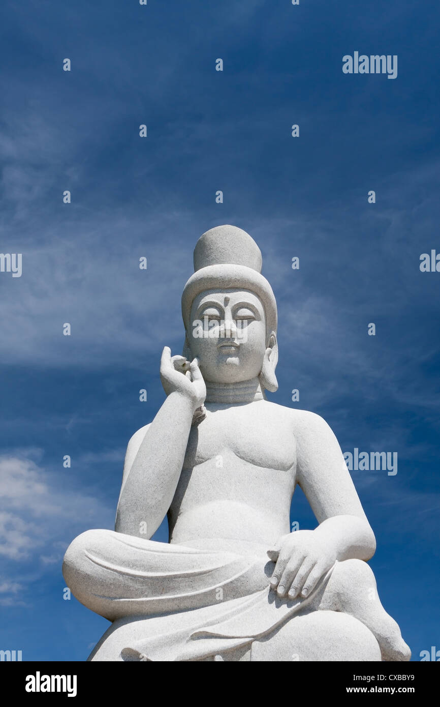 Estatua de buda de piedra antigua, estupendo para Asia Travel y los temas religiosos con el hermoso cielo azul. Foto de stock