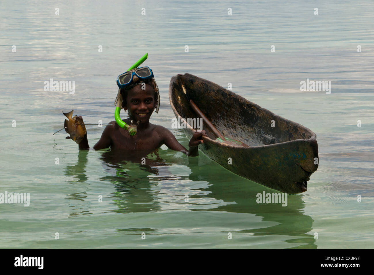 Young Boy va a su canoa y pesca con arpón, laguna Marovo, Islas