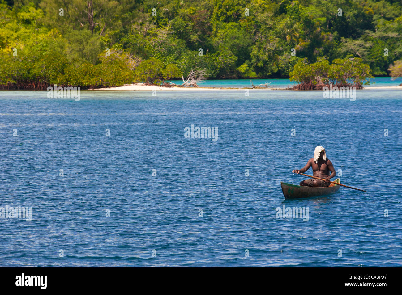 Hombre sentado en su canoa, Laguna Marovo, Islas Salomón, el Pacífico Foto de stock