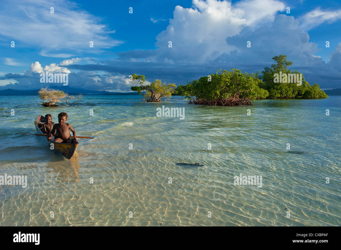Los muchachos de pesca en la laguna de Marovo abajo nubes dramáticas, las Islas Salomón, el Pacífico Foto de stock