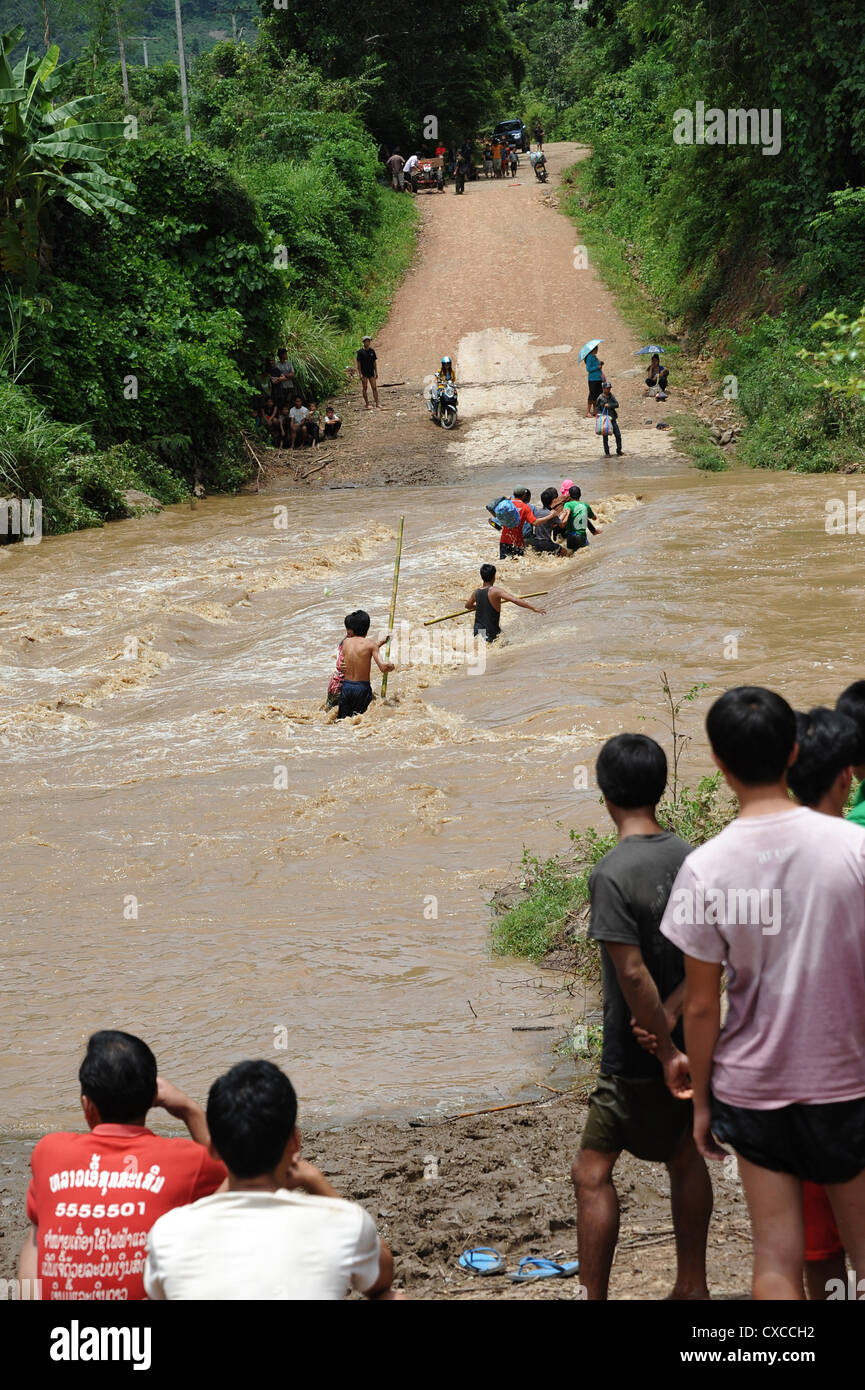 Los aldeanos lucha a través del río inundado en Banthapho Village, en Luang Prabang, Laos. Foto de stock