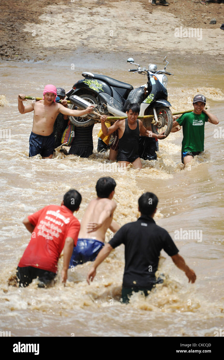 Los aldeanos lucha a través del río inundado en Banthapho Village, en Luang Prabang, Laos. Foto de stock