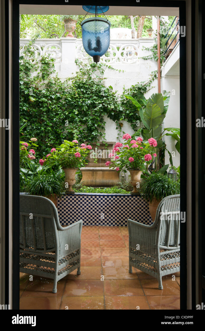 Muebles de caña gris en el jardín vallado Foto de stock