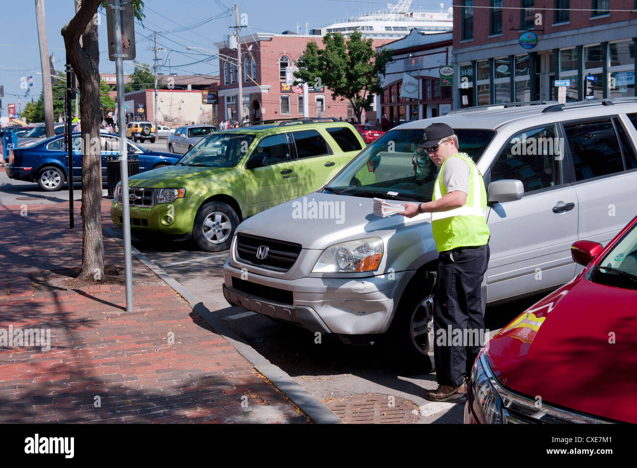 Traffic warden emite un ticket de aparcamiento en el centro de Portland, Maine, Estados Unidos. Foto de stock