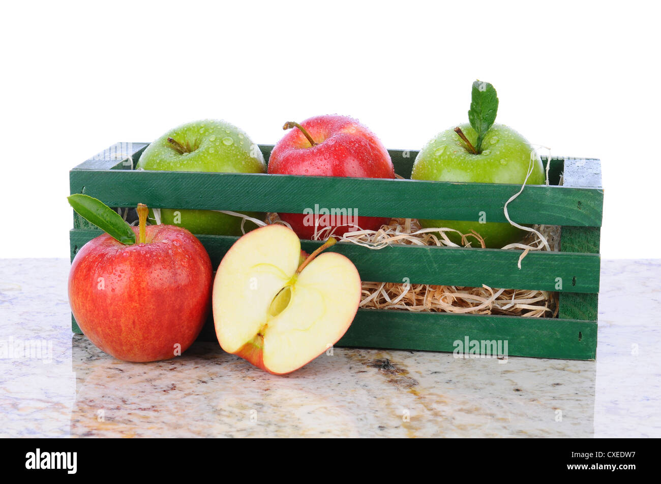 Una caja de madera con un surtido de manzanas en una mesa de granito