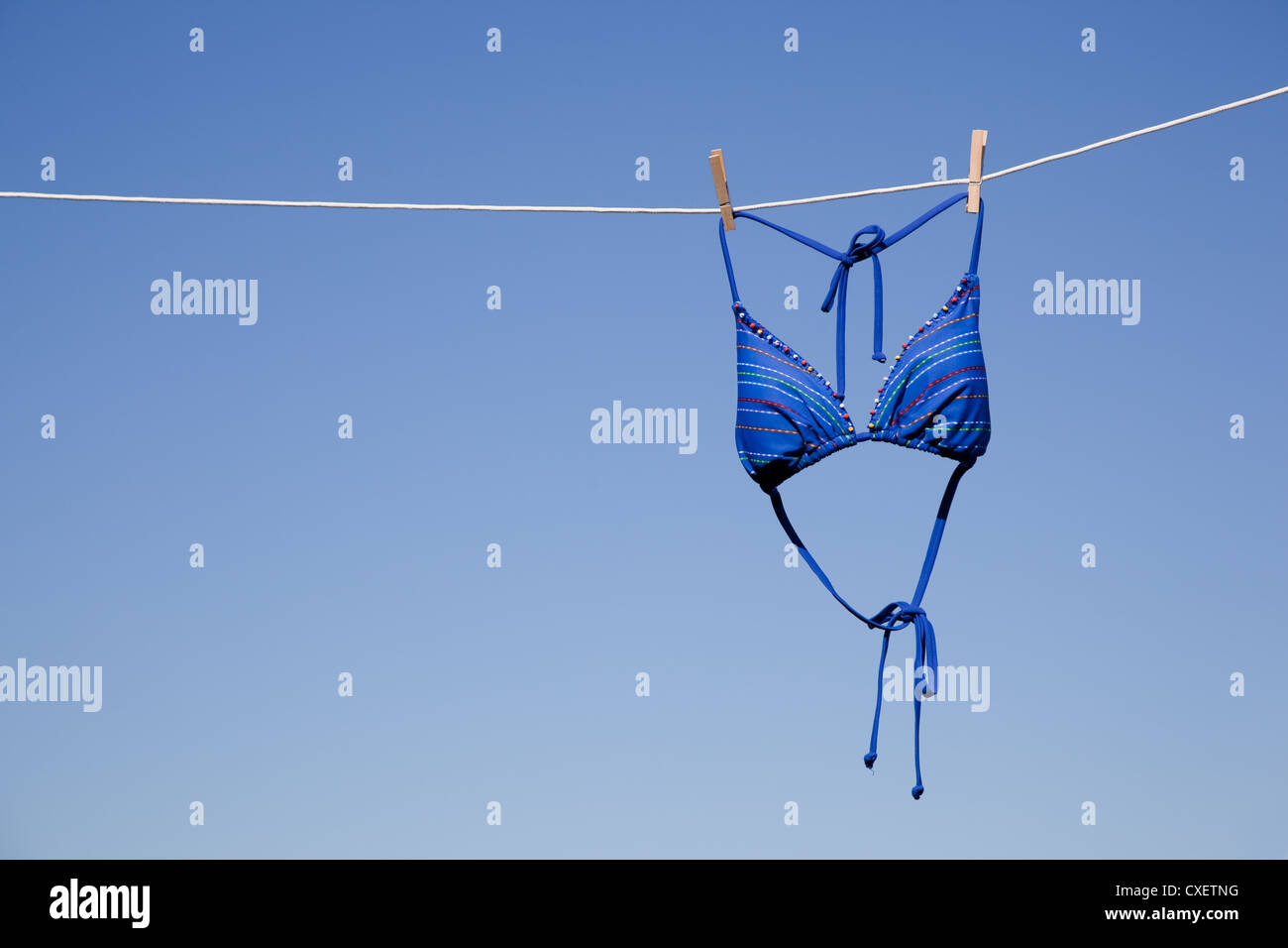 Un bikini azul colgando de un tendedero con un fondo azul cielo Fotografía  de stock - Alamy