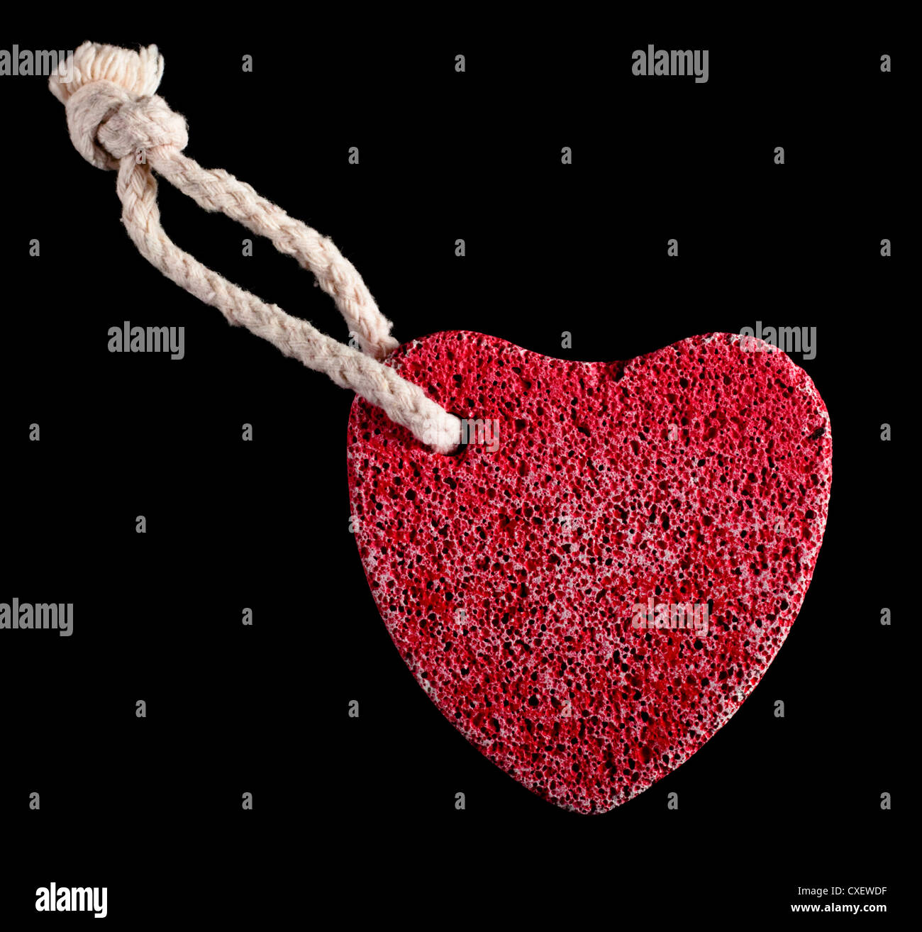 Rojo en forma de corazón de piedra con cuerda Foto de stock
