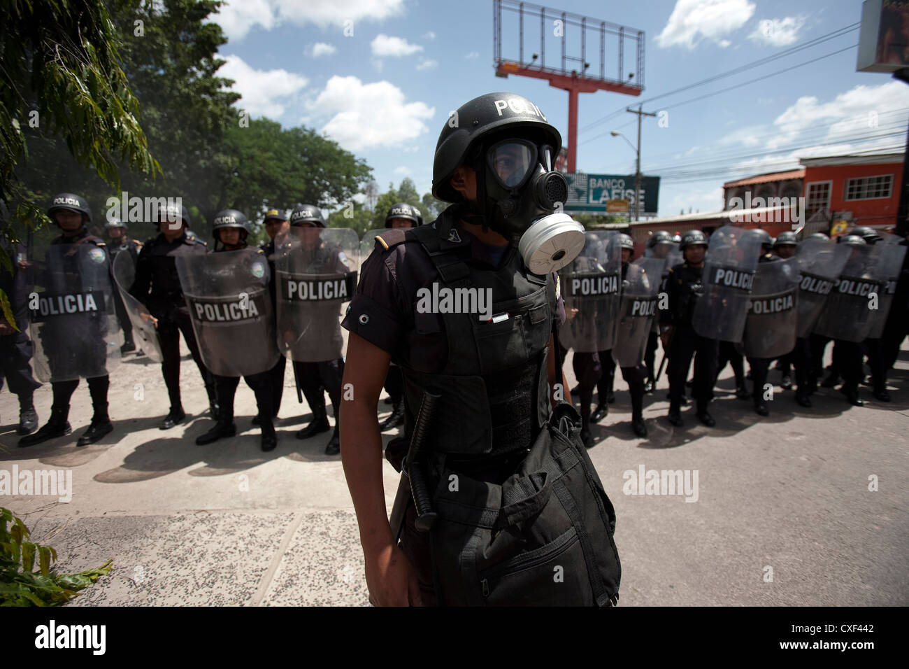 Policía hondureña guardia como miles de simpatizantes del depuesto presidente de Honduras, Manuel Zelaya, una protesta en Tegucigalpa. Foto de stock