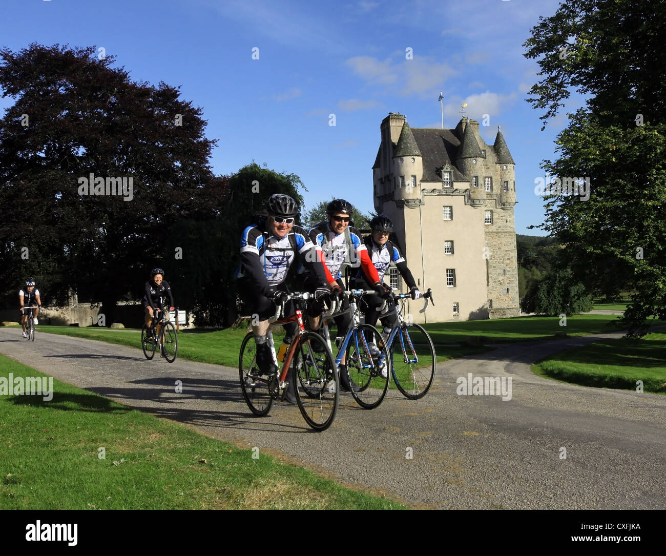 Los ciclistas de carretera ciclismo últimos Castle Fraser en Aberdeenshire, Escocia, Reino Unido, en un día soleado con el cielo azul Foto de stock