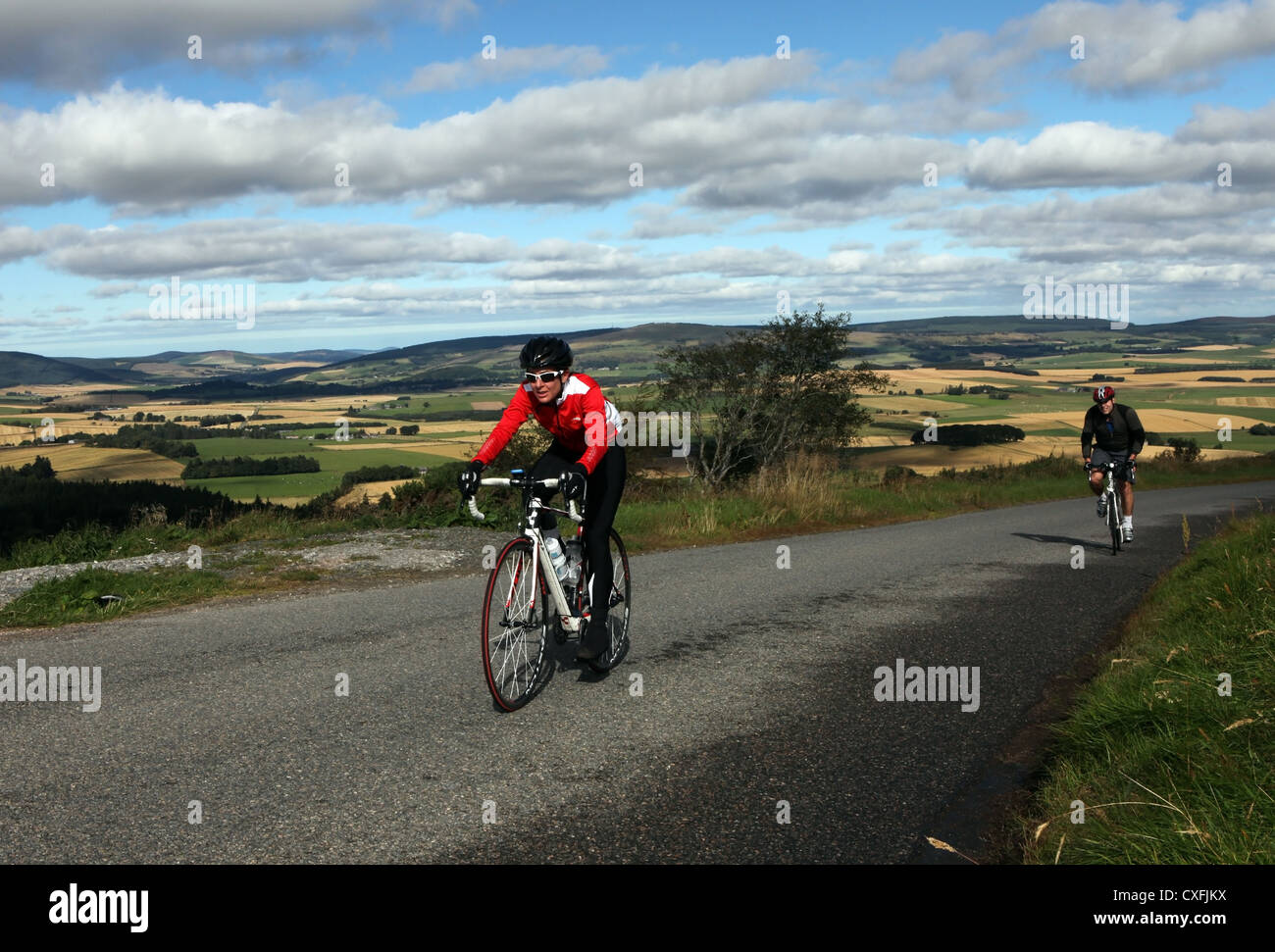 Los ciclistas de carretera en bicicleta por las carreteras escénicas en Aberdeenshire, Escocia, Reino Unido, en un día soleado con el cielo azul Foto de stock