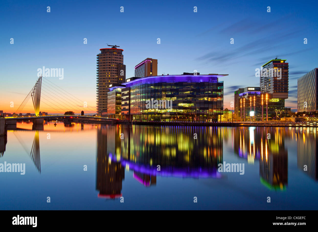 Inglaterra, Greater Manchester, Salford Quays, Media City y el puente colgante en penumbra Foto de stock